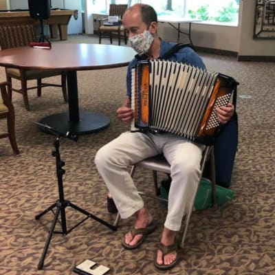 Man playing an accordian at Landings of Minnetonka in Minnetonka, Minnesota