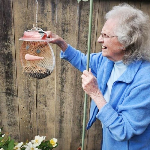 A resident feeding birds at Glen Carr House Memory Care in Derby, Kansas