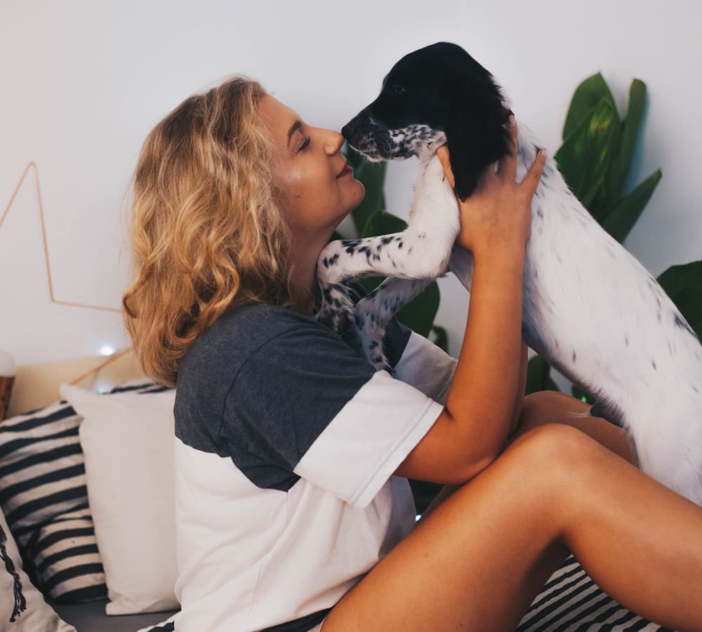 Resident giving her dog a kiss in their new home at Sofi Ventura in Ventura, California