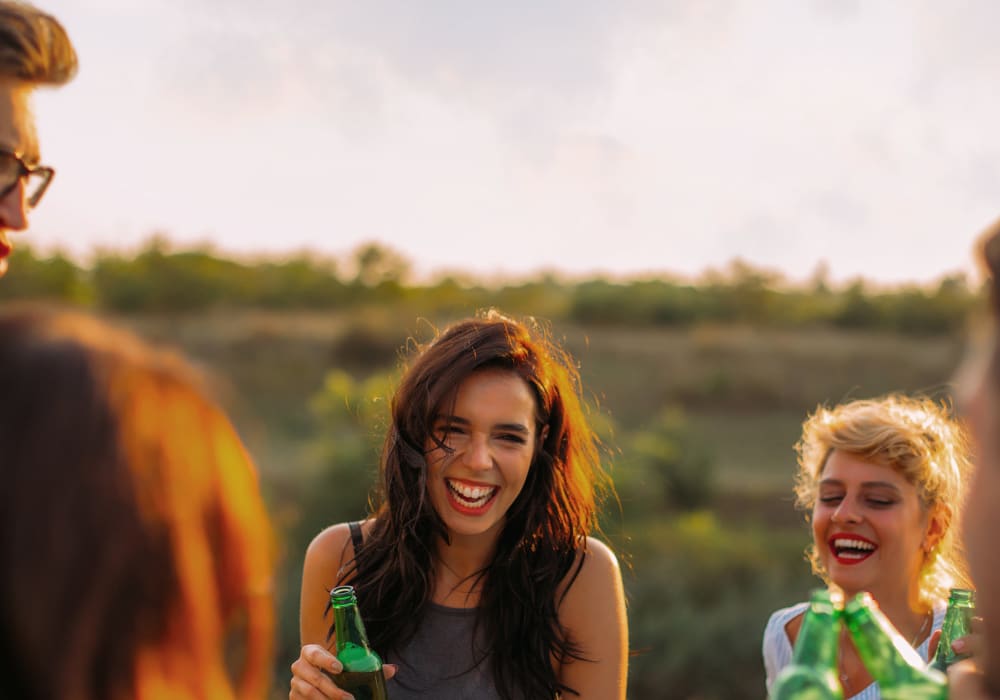 Resident friends enjoying cold beverages outside at Sofi at Murrayhill in Beaverton, Oregon