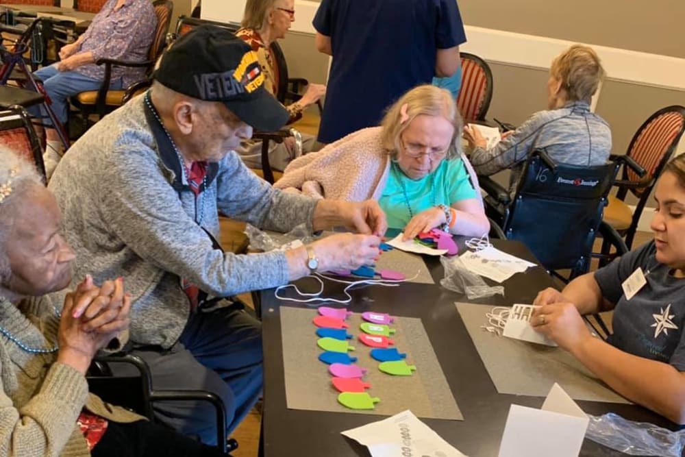 Residents and a staff member playing a game at Inspired Living Sun City Center in Sun City Center, Florida. 