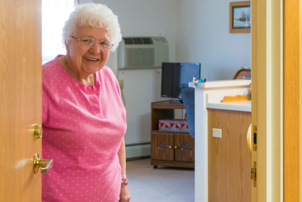 Resident welcomes visitor to her apartment at Meadow Lakes Senior Living in Rochester, Minnesota.