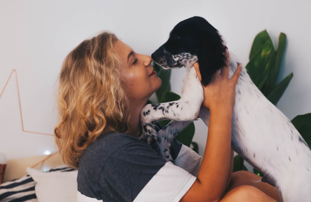 Resident giving her puppy a kiss in her new home at Haven Warner Center in Canoga Park, California