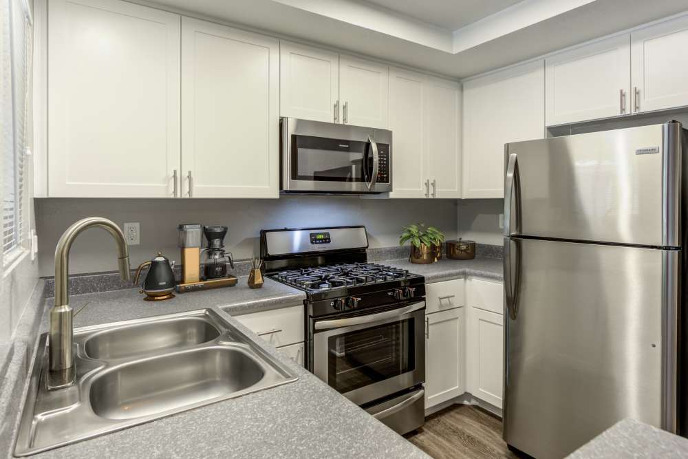 Renovated kitchen with white cabinets and stainless steel appliances at Village Oaks in Chino Hills, California