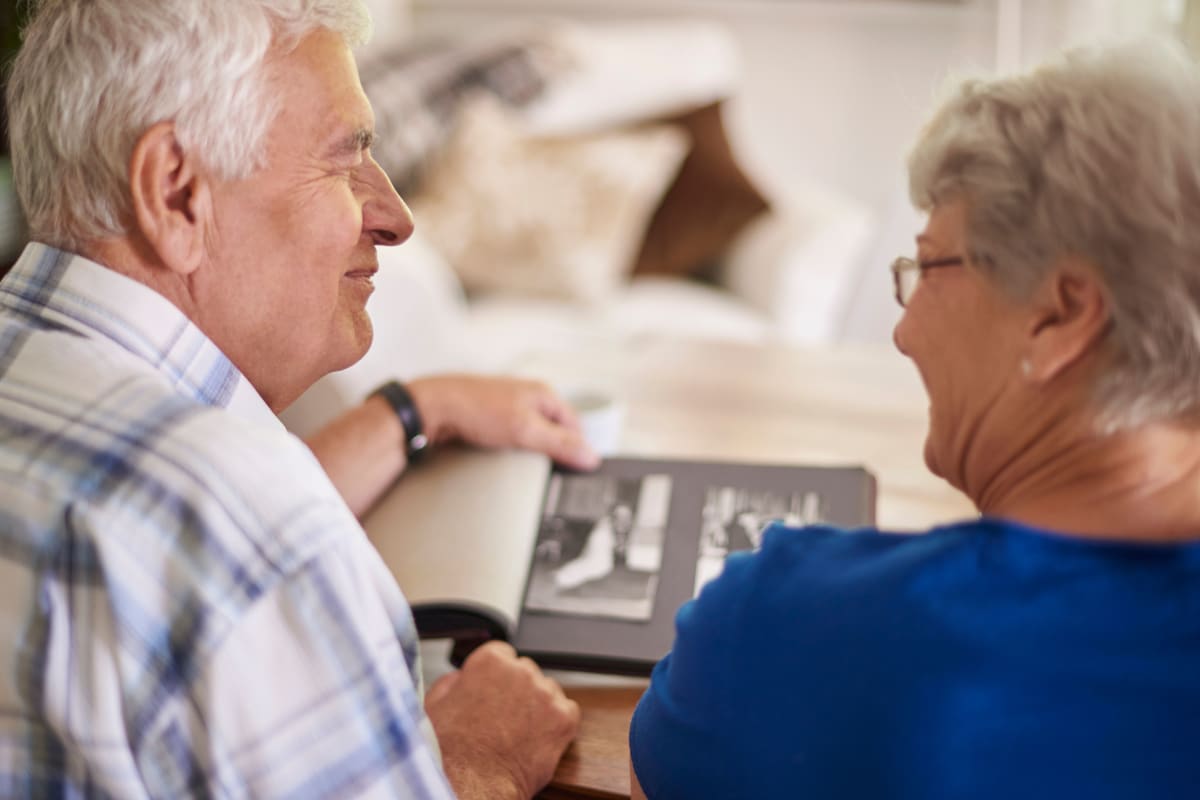 Two people looking at photos at Canoe Brook Assisted Living & Memory Care in Catoosa, Oklahoma