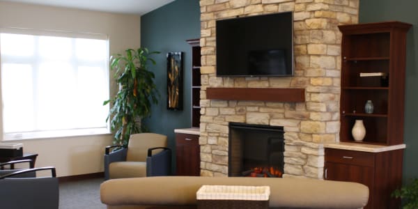 Common living room area with cozy resident fireplace at East Troy Manor in East Troy, Wisconsin