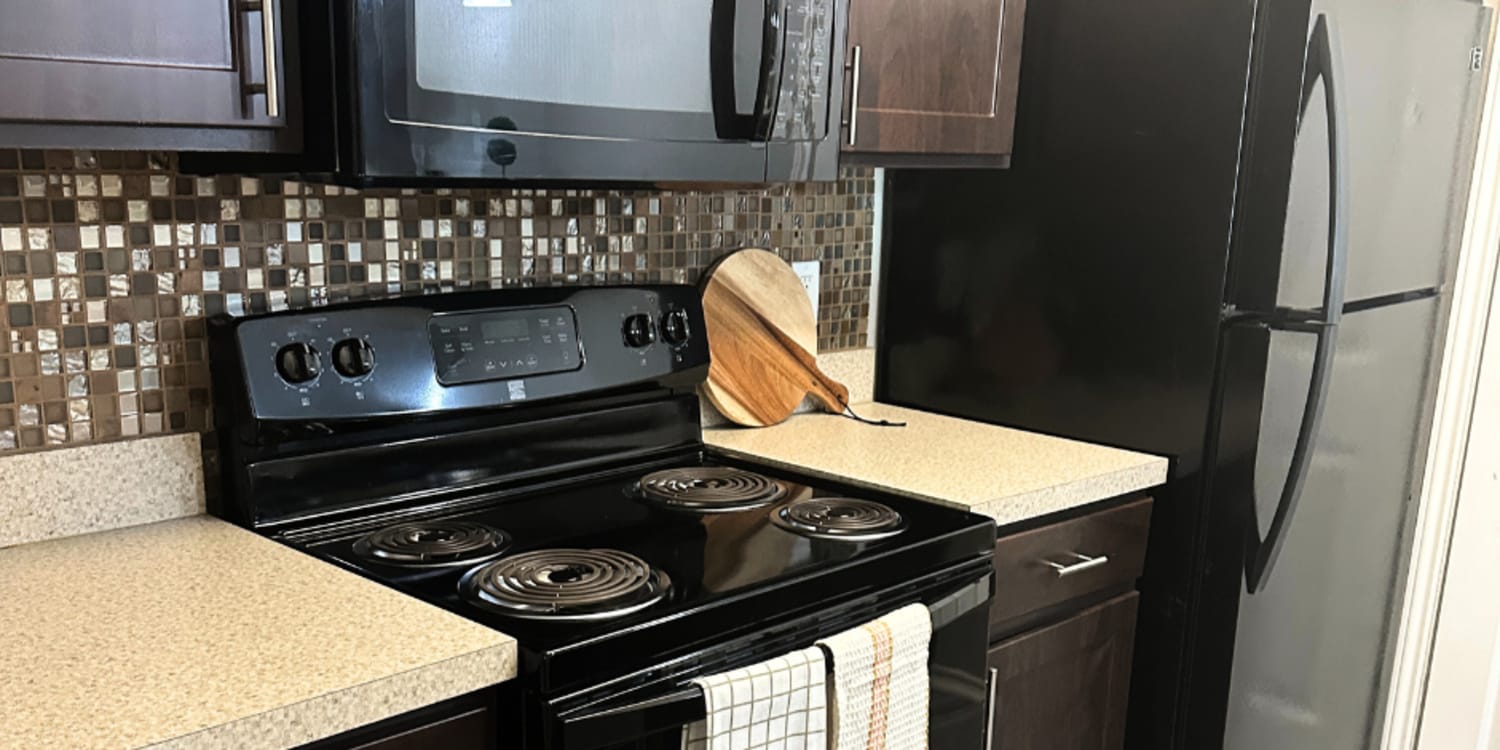 Kitchen with black appliances at Walnut Ridge in Arlington, Texas