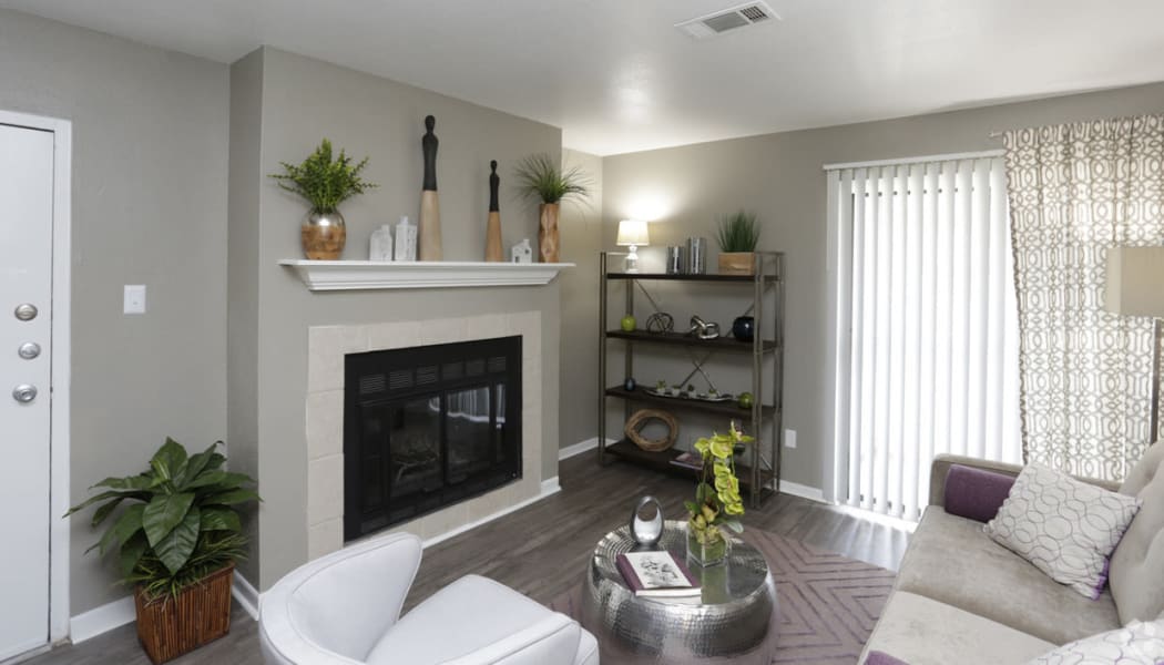 Spacious living room with hardwood style flooring and fireplace at EnVue Apartments in Bryan, Texas