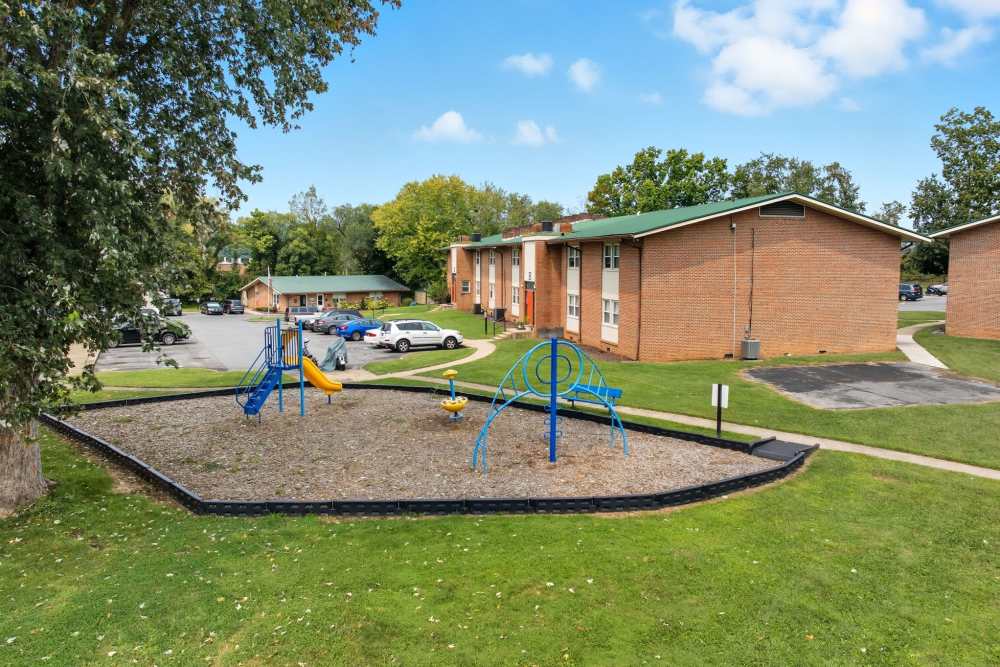 Green lawn outside of leasing office with kids play area at Bristol Square Apartments in Bristol, Tennessee