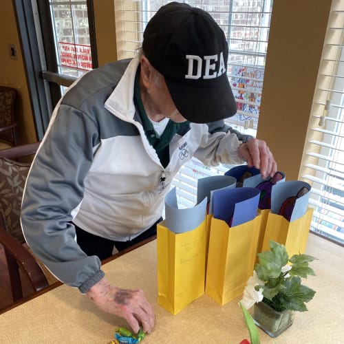 A resident looking through gift bags at Oxford Glen Memory Care at Carrollton in Carrollton, Texas