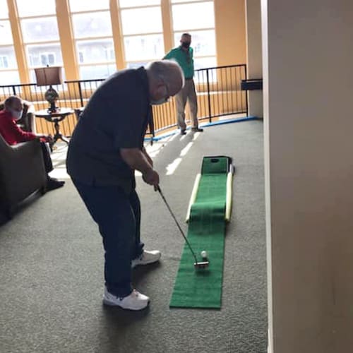 Resident playing indoor minigolf at The Oxford Grand Assisted Living & Memory Care in McKinney, Texas