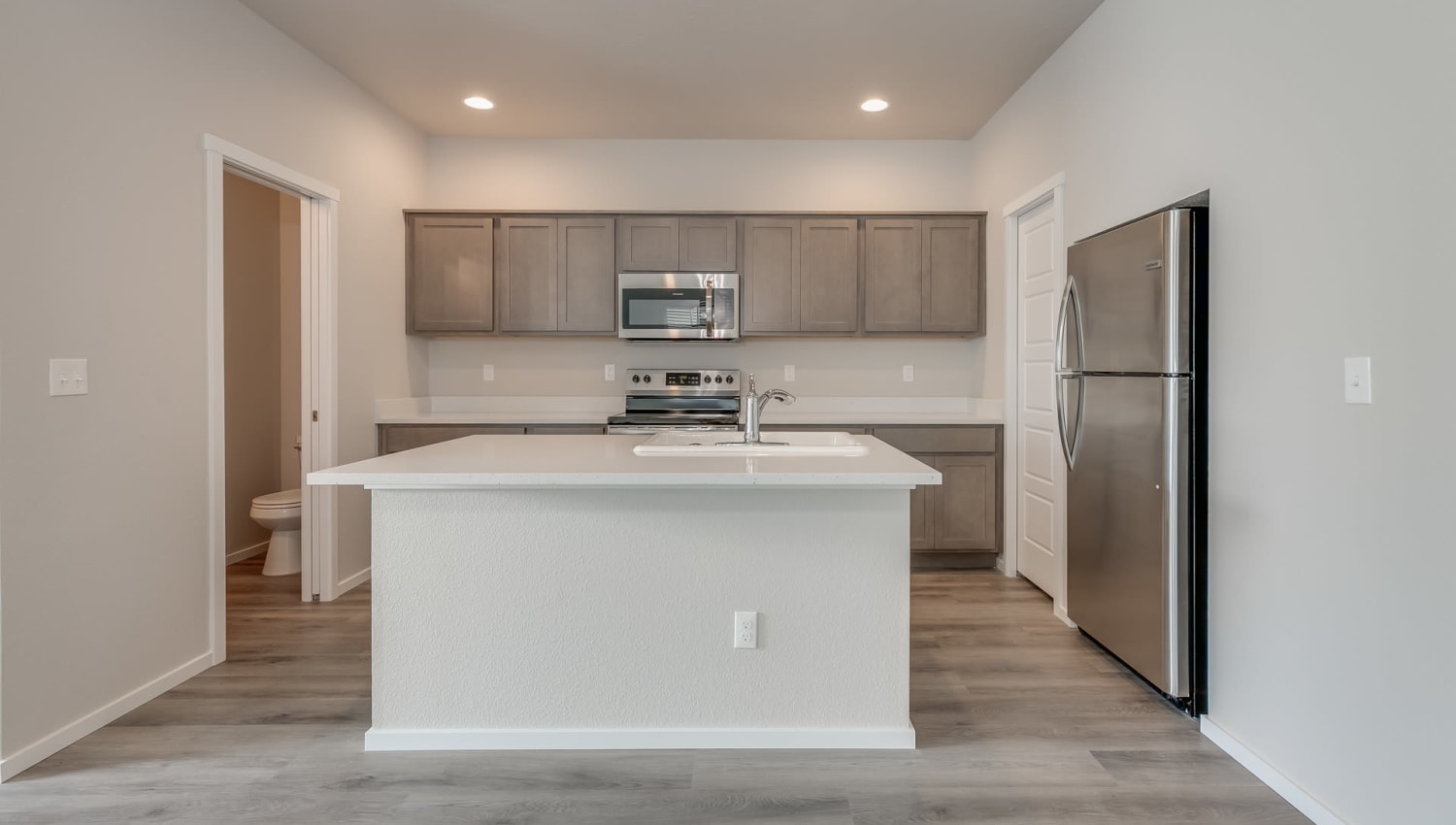 Kitchen with stainless-steel appliances and a large island at Olympus at Ten Mile in Meridian, Idaho