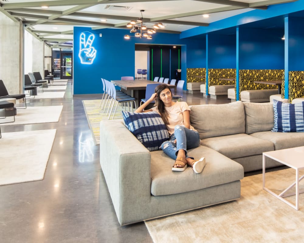 Resident relaxing in common area at RISE at Riverfront Crossings in Iowa City, Iowa
