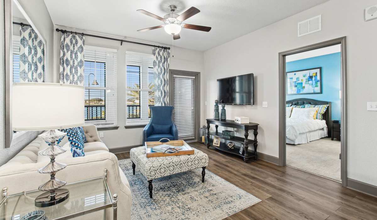 Spacious living room with couch, chair, coffee table and flat screen television at The Addison on Millenia in Orlando, Florida