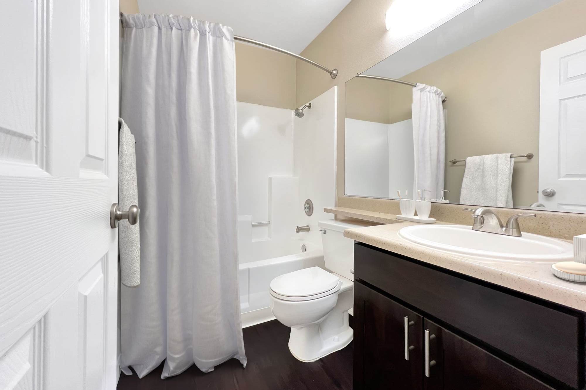A renovated bathroom with brown cabinets at Hillside Terrace Apartments in Lemon Grove, California