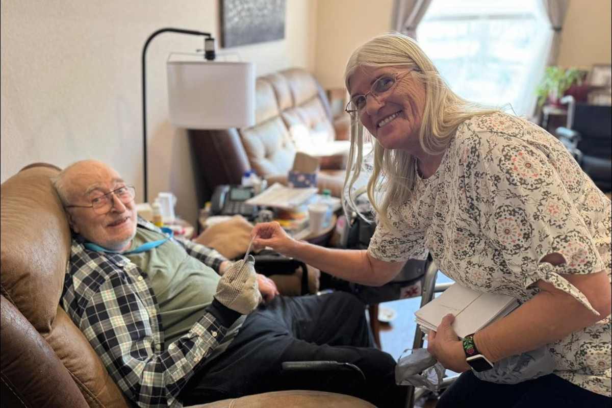 A woman assists an elderly man seated beside her at Isle at Cedar Ridge in Cedar Park, Texas.