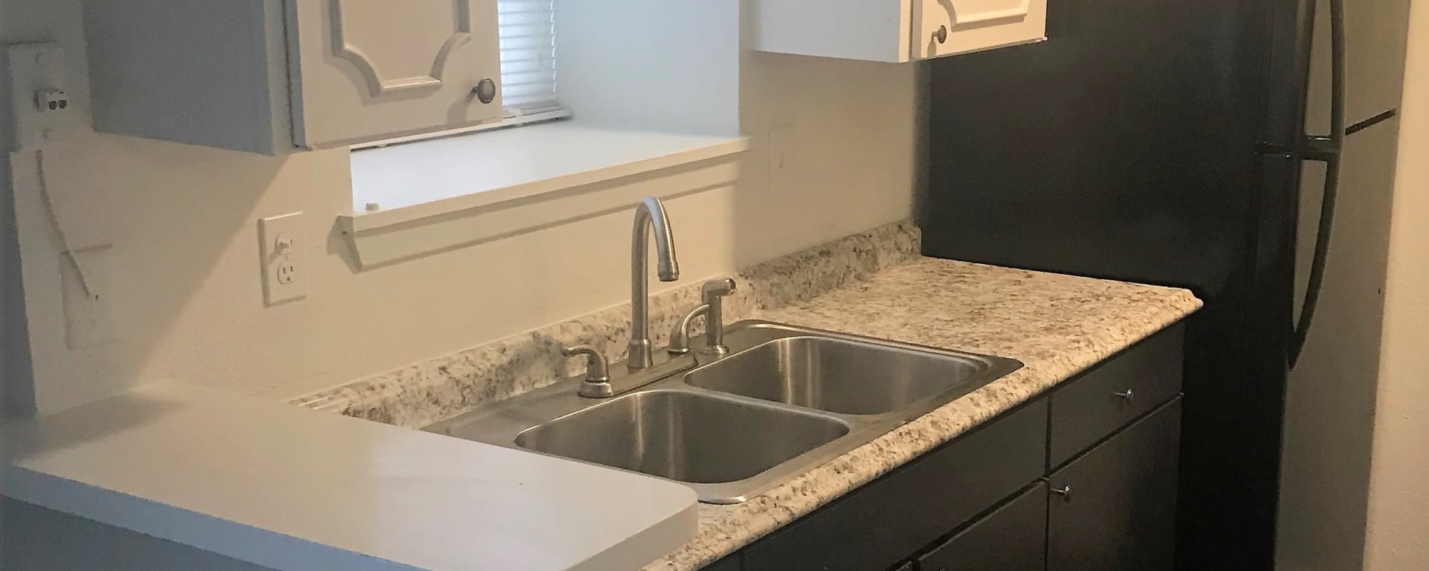 Apartment kitchen with stainless-steel appliances at Arbors on 31st in Bryan, Texas