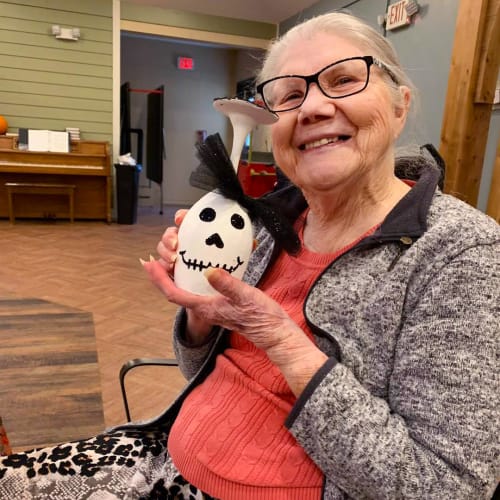 Smiling resident holding a decorated vase at Oxford Glen Memory Care at Owasso in Owasso, Oklahoma