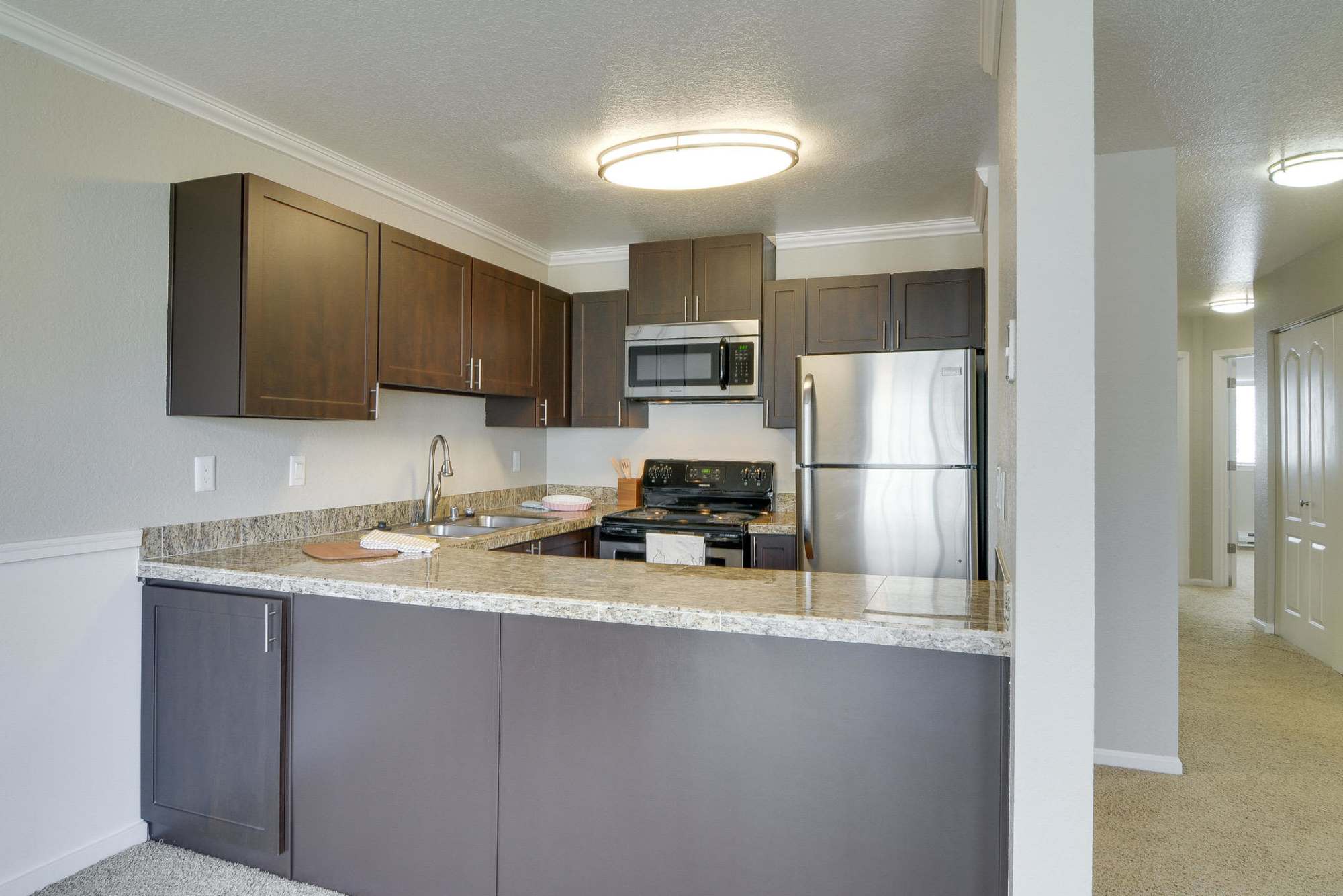 Kitchen with view to hallway at Carriage House Apartments in Vancouver, Washington