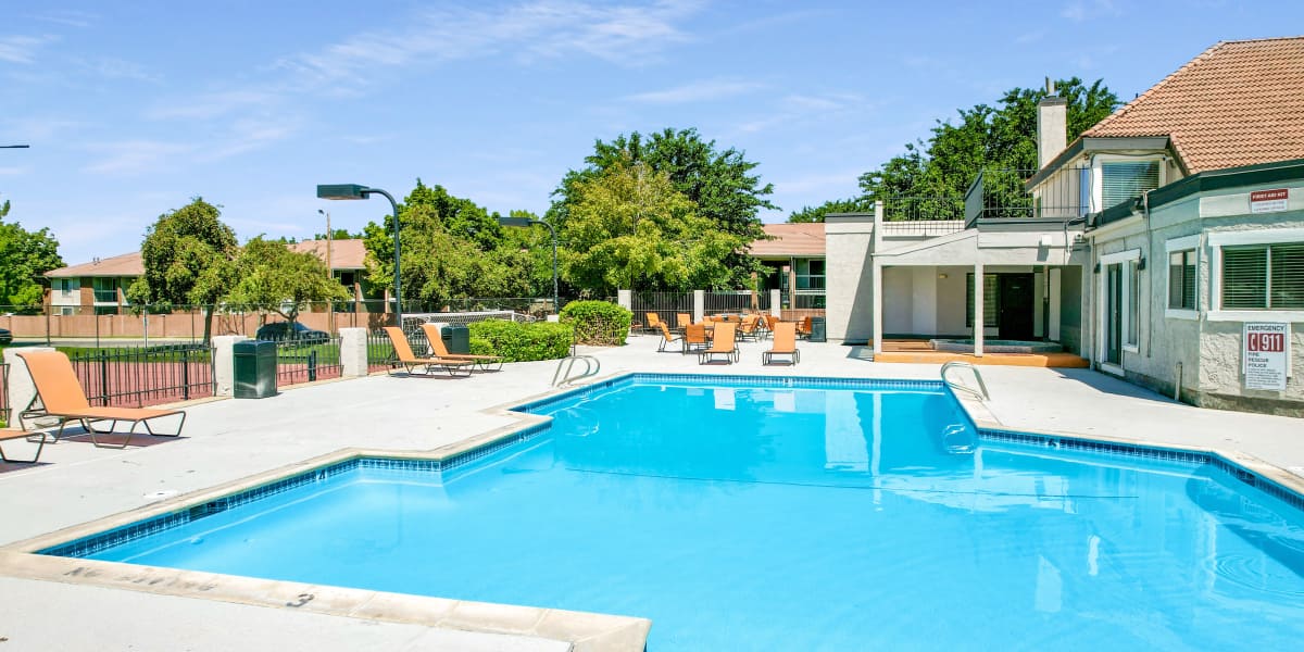 Beautiful resort-style swimming pool with lounge chairs at Shadowbrook Apartments in West Valley City, Utah