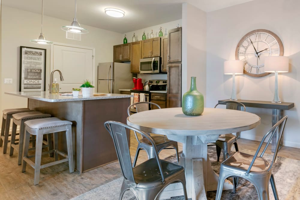 Dining area and modern kitchen with breakfast bar at The Village at Apison Pike in Ooltewah, Tennessee