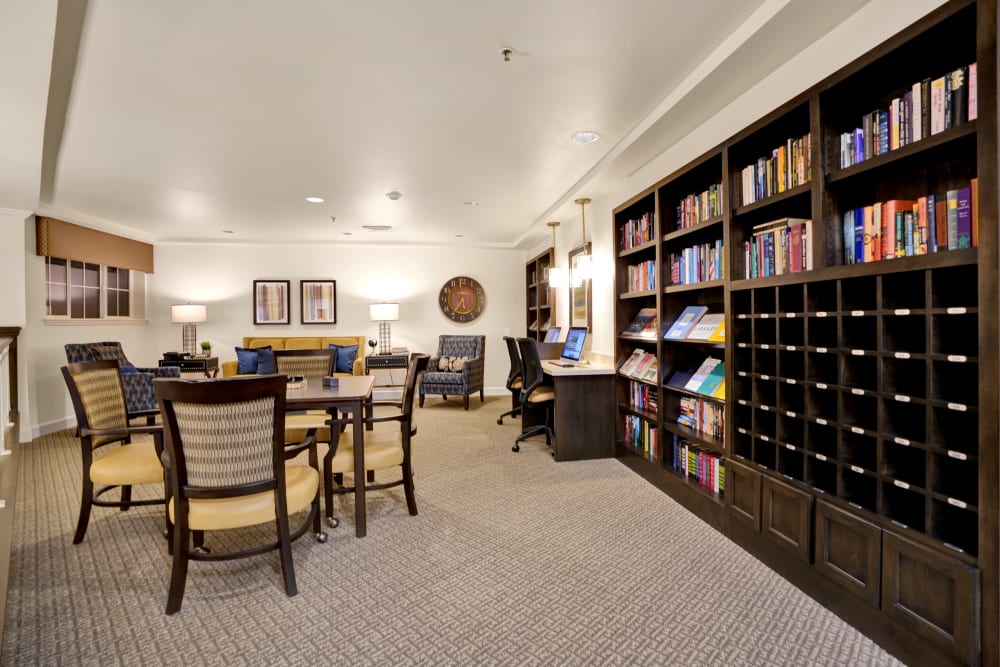 Large room with tables and chairs sitting beside a large book shelf at The Commons at Dallas Ranch in Antioch, California