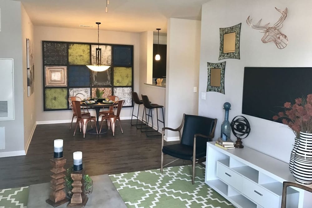 Living room and dining area with hardwood style flooring at Creekside at Kenney's Fort in Round Rock, Texas