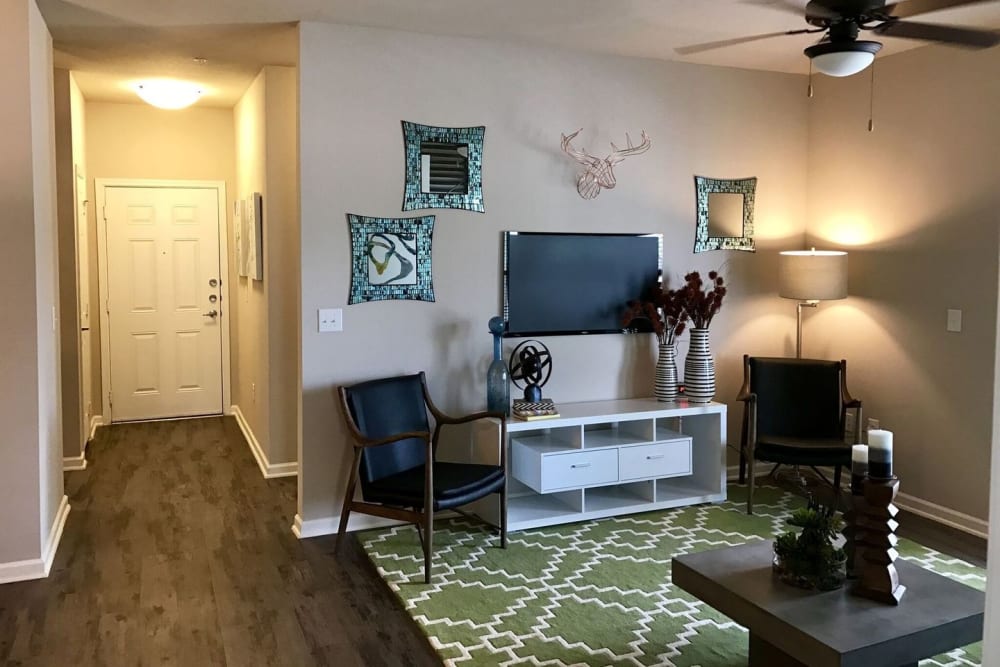 Model living room area with hardwood style flooring at Creekside at Kenney's Fort in Round Rock, Texas