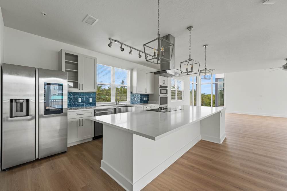 Modern kitchen with island and stainless steel appliances at Coconut Pointe in Estero, Florida