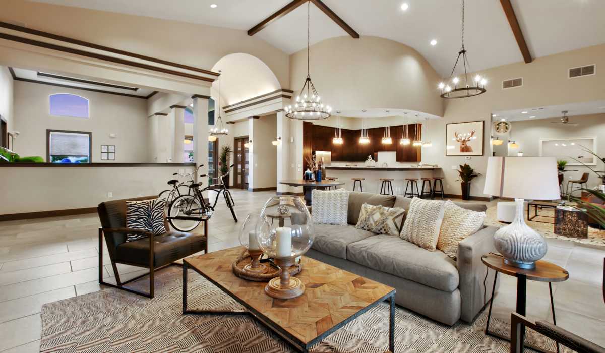 Community clubhouse with large couch, chair and chandelier at Canyon House in New Braunfels, Texas