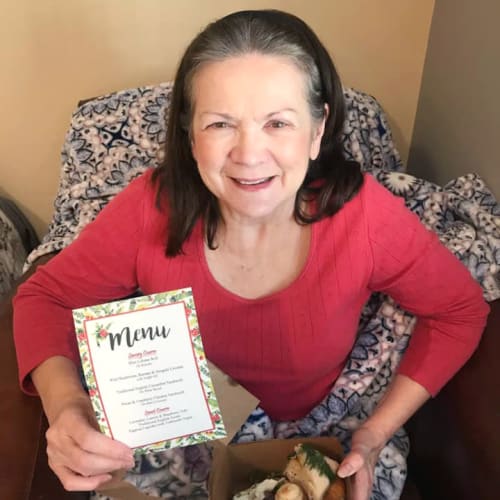 resident holding a box of various sweets at The Oxford Grand Assisted Living & Memory Care in McKinney, Texas