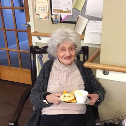A resident sitting with a breakfast plate at Canoe Brook Assisted Living & Memory Care in Catoosa, Oklahoma