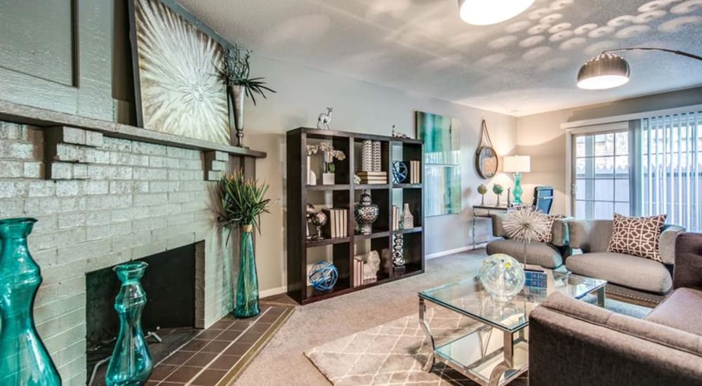 Leather couch and a comfortable chair in a model home's living space at London House Apartments in Lenexa, Kansas