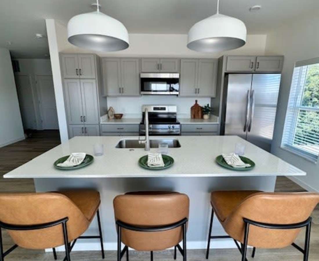 Kitchen island with bar stools and plates at Pritchard Park Place in Racine, Wisconsin
