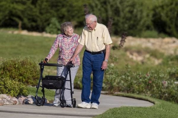 Elderly couple talking a walk through the park The Oxford Grand Assisted Living & Memory Care