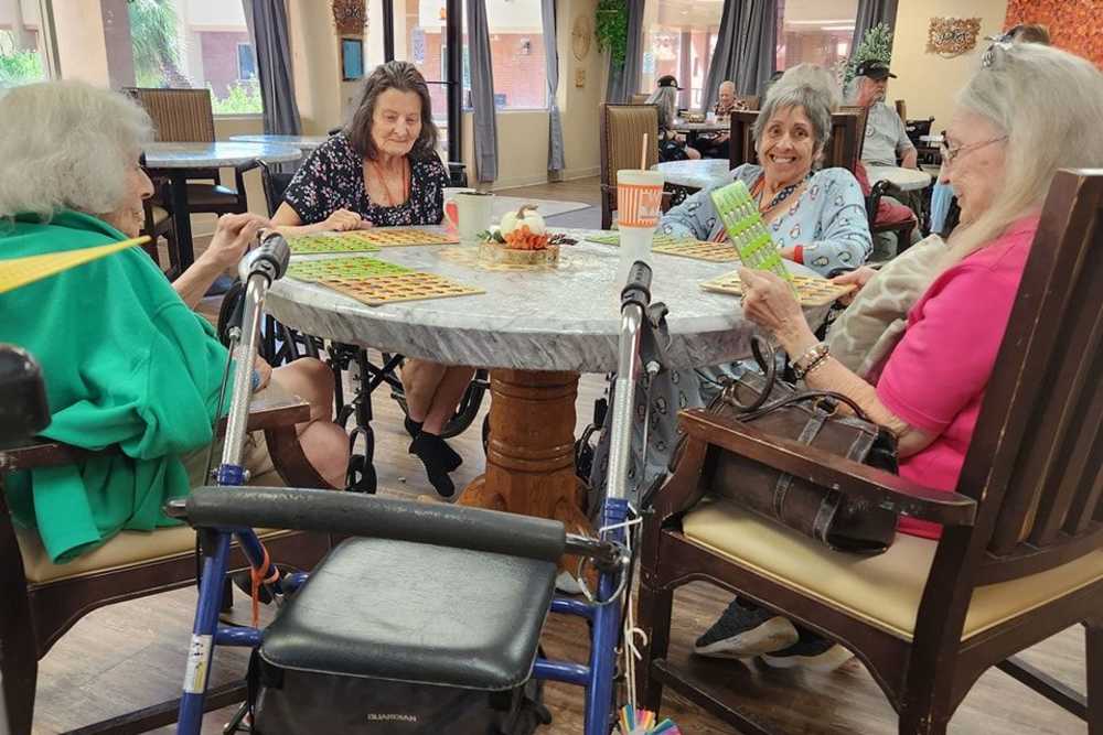 Ladies playing a card game at Woodland Palms Memory Care in Tucson, Arizona