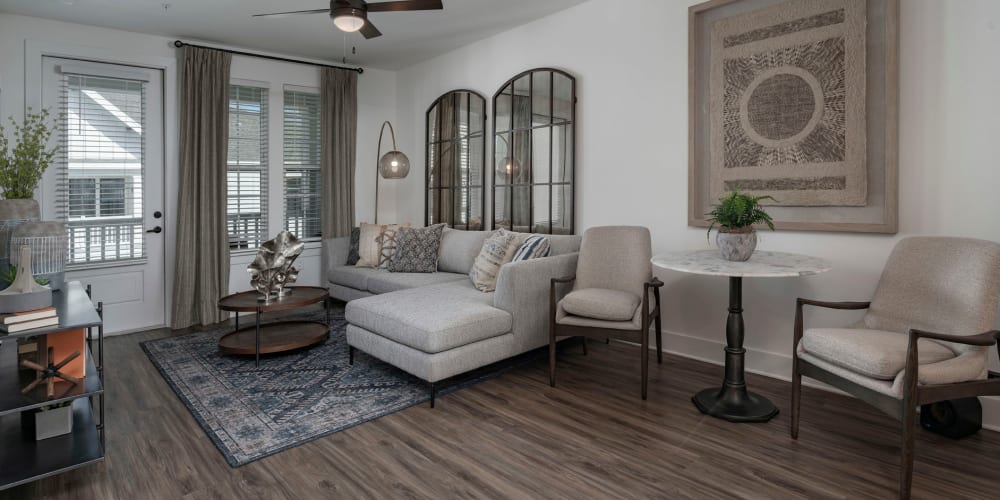 Draped bay windows and modern furnishings in a model home's living area at The Atwater at Nocatee in Ponte Vedra, Florida