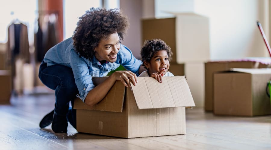 A parent playing with a child in a moving box near KO Storage in Brackettville, Texas