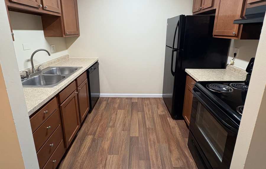 Modern kitchen with black appliances at Edgewood Group Apartments in Merrillville, Indiana