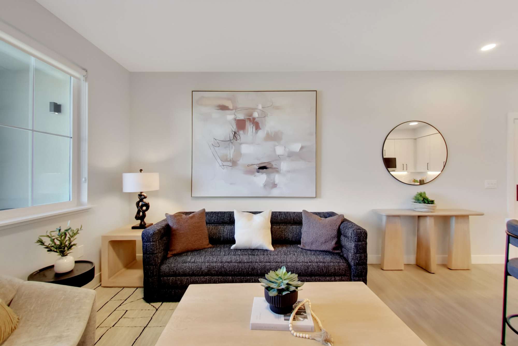 Modern living room with wood-style flooring, stylish couch, and decorative art on the wall at Domaine at Napa Junction in American Canyon, California