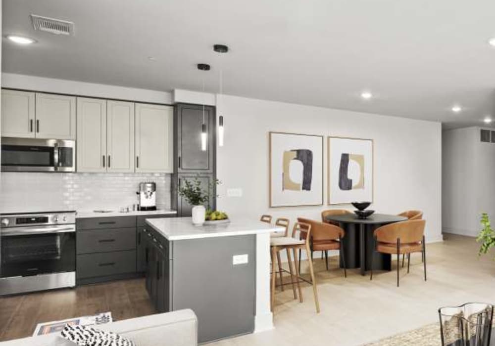 Kitchen and dining area of a modern apartment home at The Maximilian at Stonefield in Charlottesville, Virginia