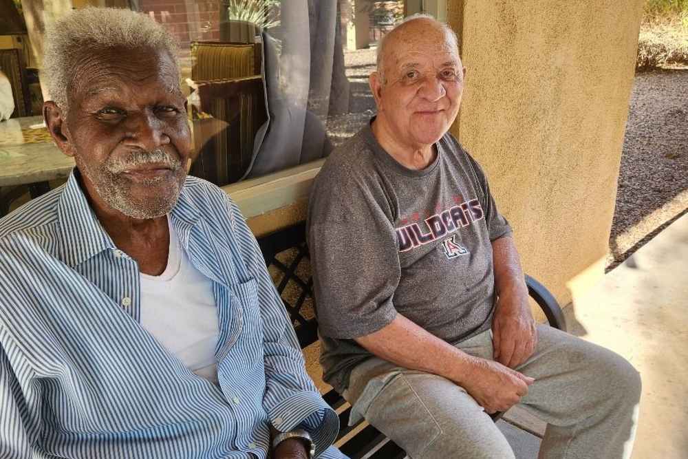 Two old men sitting outside at Woodland Palms Memory Care in Tucson, Arizona