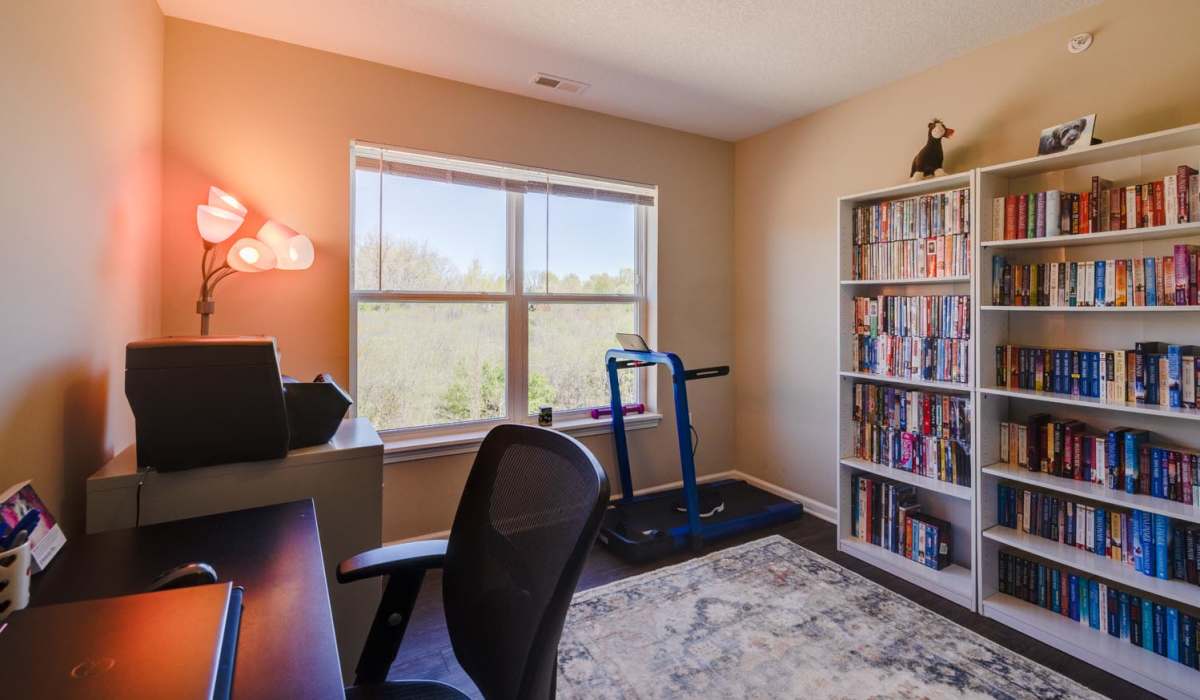 Home office with desk, bookshelf, and exercise equipment at Williams Terrace in Indianola, Iowa