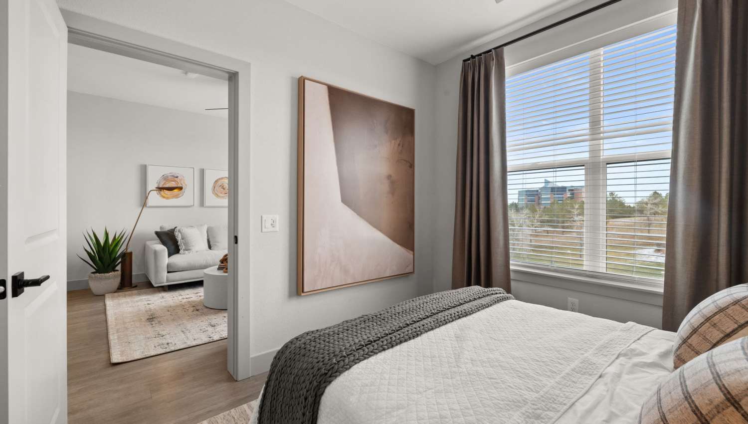 Spacious bedroom with large comfortable bed and large window at The Lock at Flatirons in Broomfield, Colorado