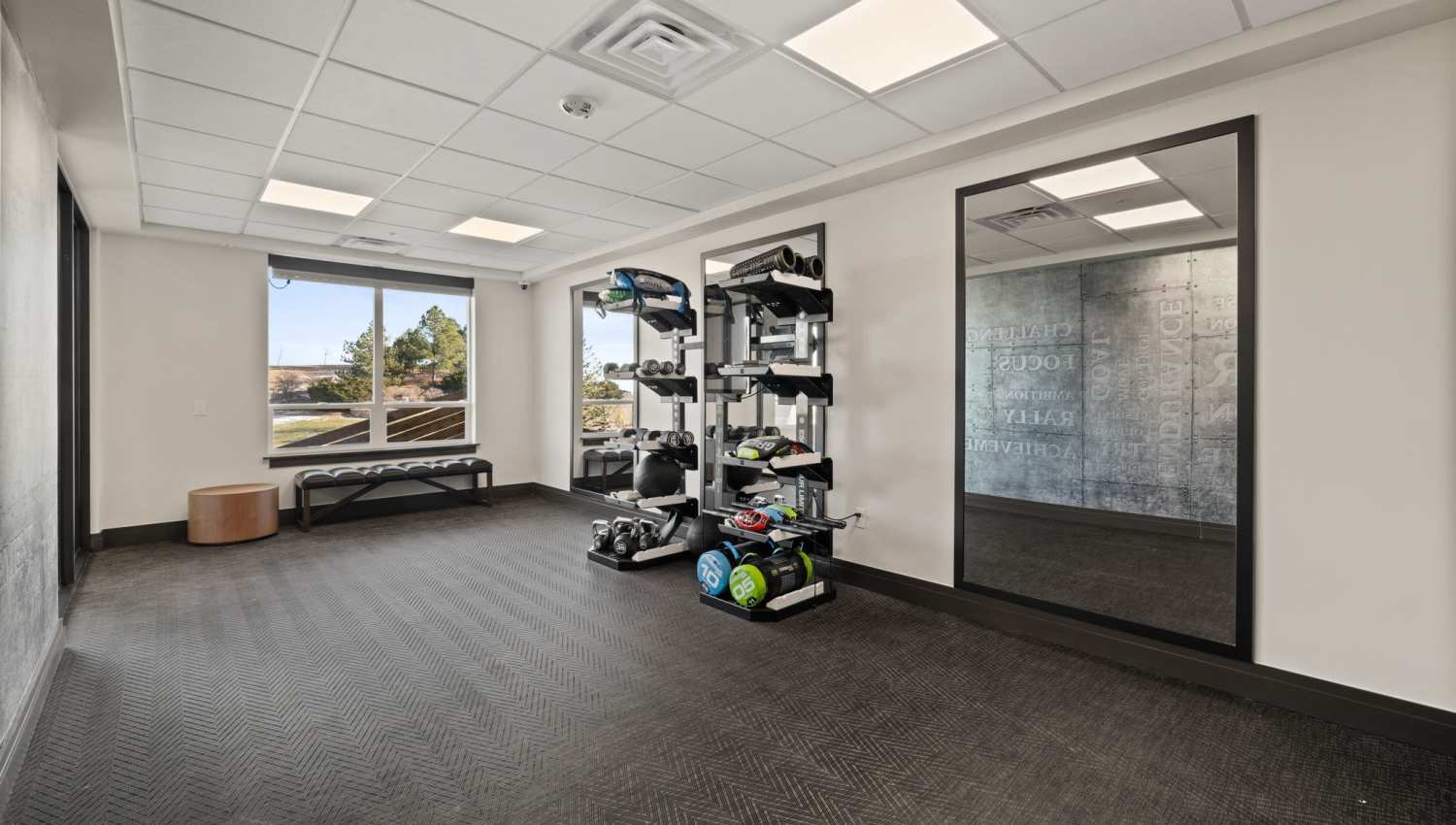Fitness center with benches and dumbbell rack at The Lock at Flatirons in Broomfield, Colorado
