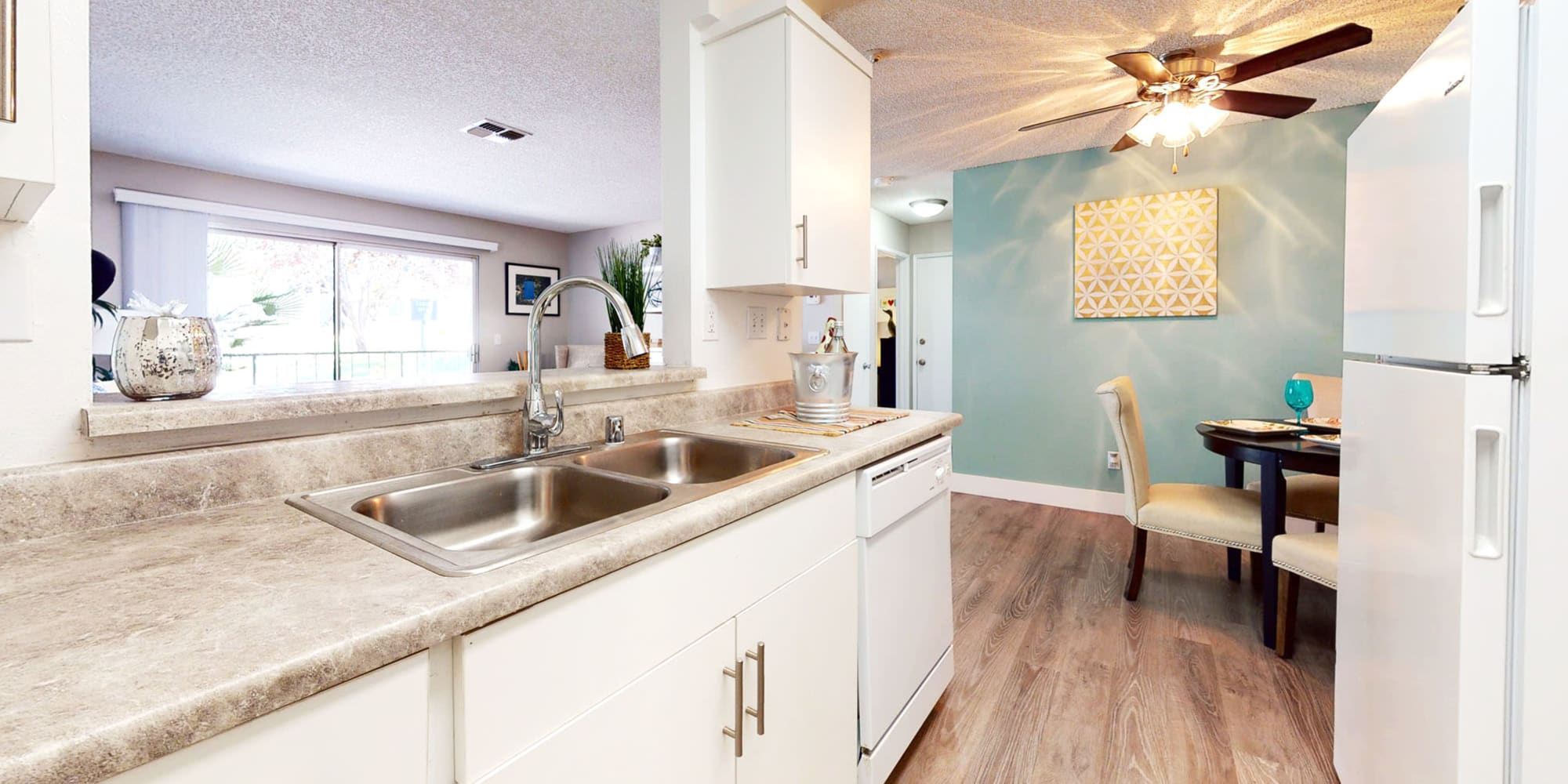 View of the dining area with an accent wall from a model home's kitchen at Mountain Vista in Victorville, California