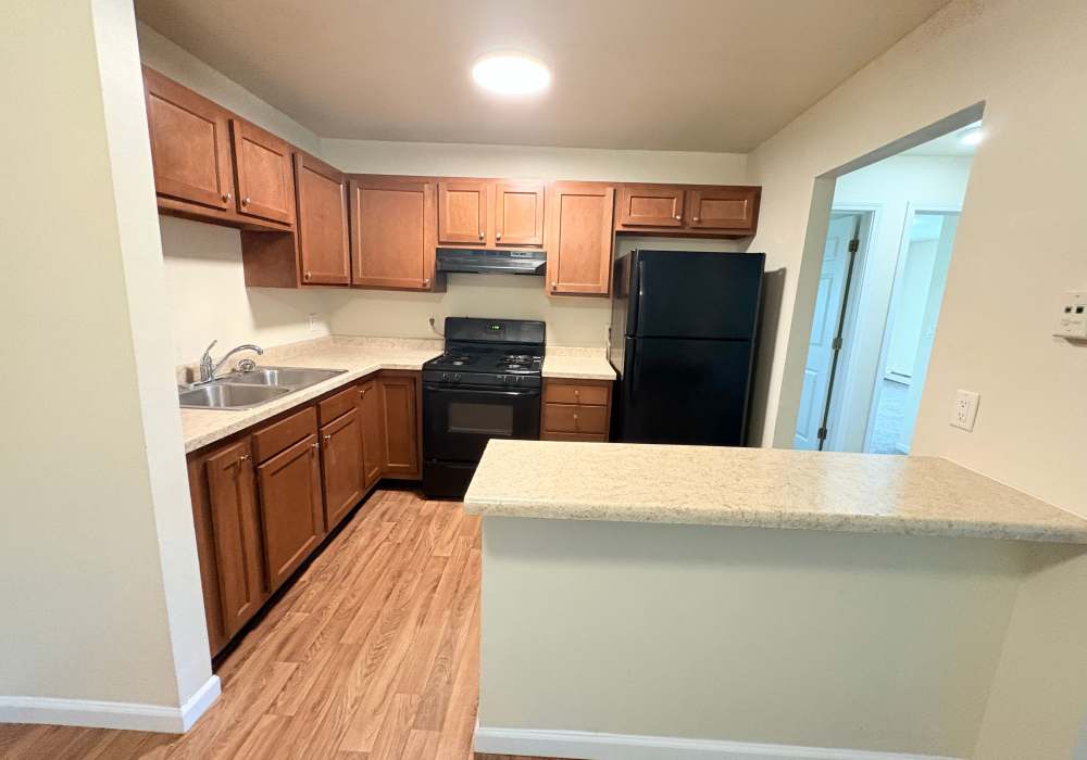Apartment kitchen with stainless steel appliances and wooden cabinets at Edgewood Group Apartments in Merrillville, Indiana