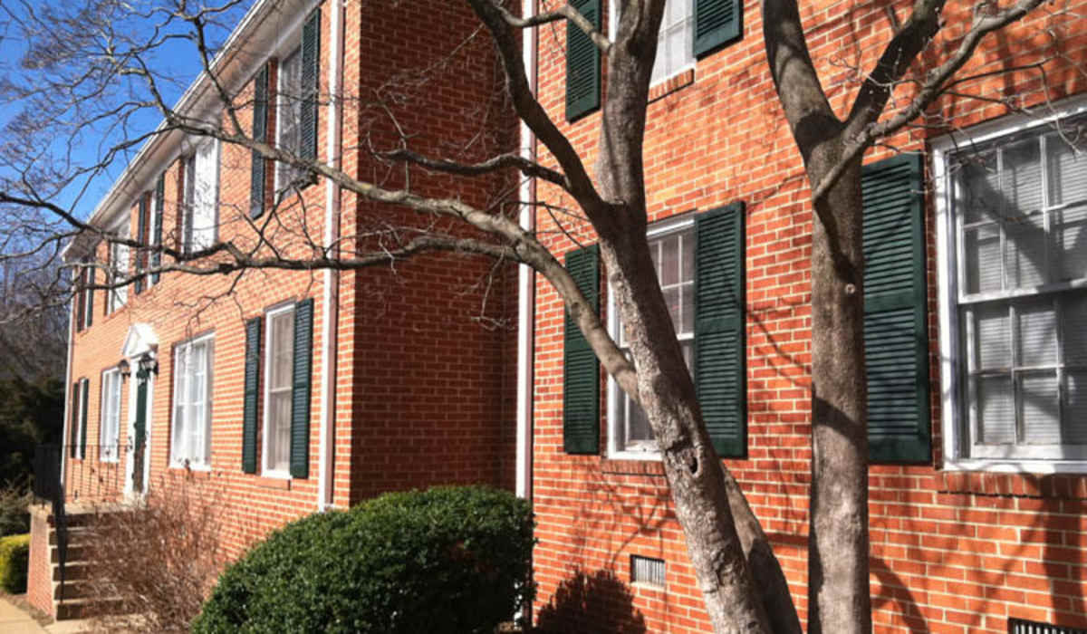 View of exterior of apartments and green lawn at Berkshire and Barter Court Apartments in Charlottesville, Virginia