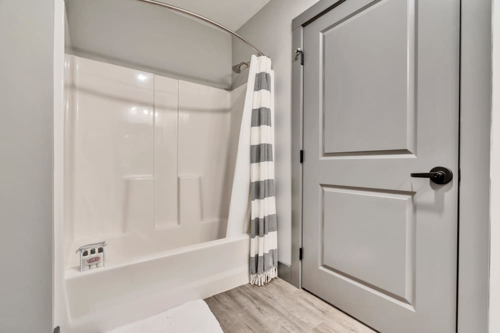 White shower with gray striped curtain at Latitude at South Portland in Portland, Maine