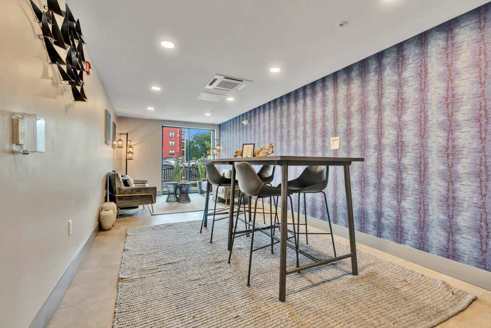 Gray rug with a table and chairs at Latitude at South Portland in Portland, Maine